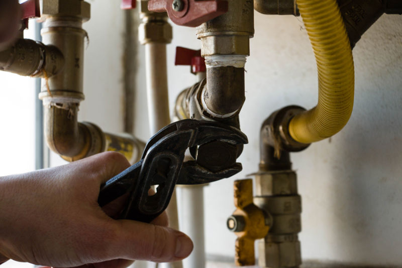 One man repair gas boiler with wrenches