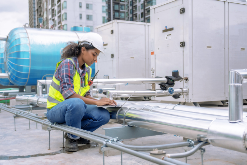 Why Is a Commercial AC Tune-Up Important? Woemn on roof.