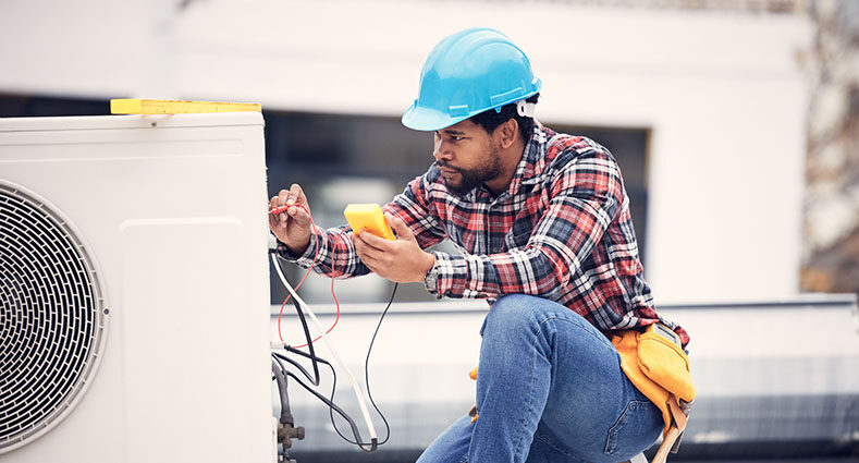 5 Benefits of Planned Commercial HVAC Maintenance. Air conditioner, cables and technician man ac repair, maintenance or working on electrical power generator. African person, electrician or contractor with electricity, heat pump check and engineering.