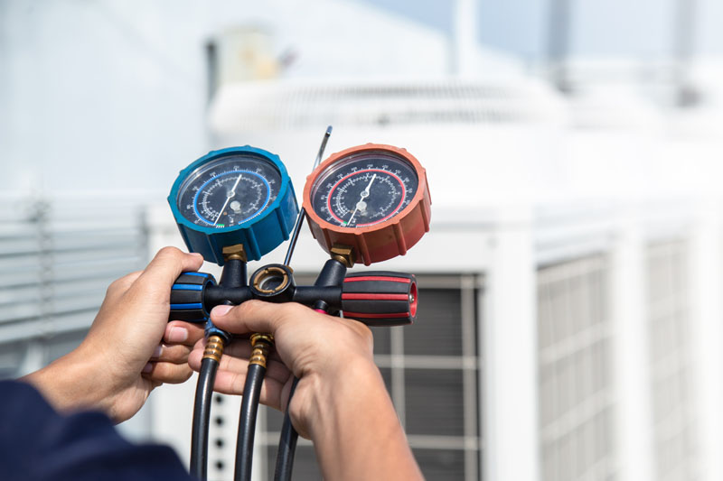 Technician is checking air conditioner ,measuring equipment for filling air conditioners