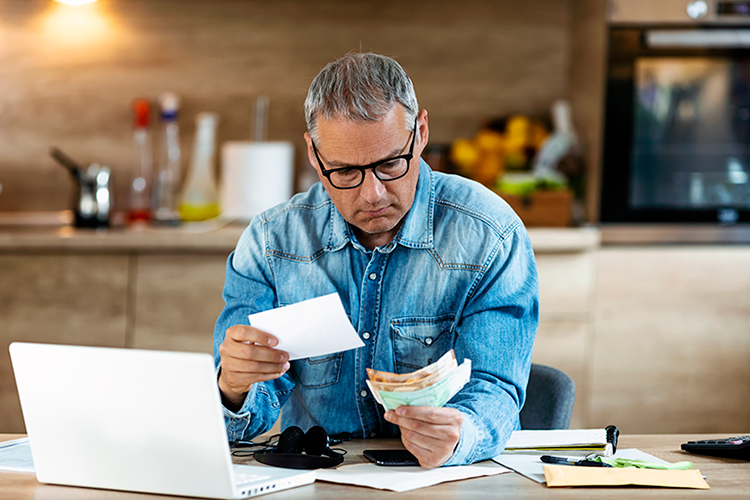 What Are the Benefits of a Rooftop HVAC Unit? Image is a photograph at a man wearing glasses and a blue button down sitting at a desk and reviewing flash cards.