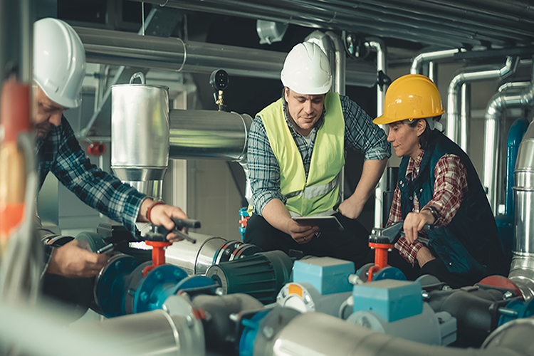 3 People work on a commercial HVAC unit. My Commercial Boiler Makes Banging Sounds.